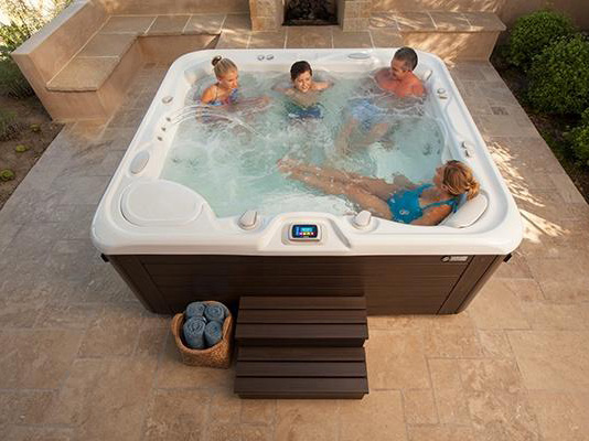 A group of friends experiencing the ultimate relaxation in a HotSpring Grandee hot tub, known for its top-rated performance and comfort.