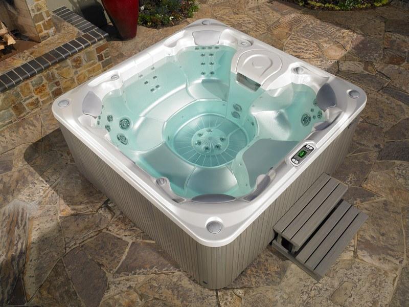 A luxurious Hot Spring spa with a heat-retaining shell, filled with crystal-clear water, featuring ergonomic seating and multiple hydrotherapy jets.