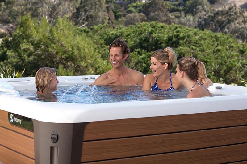A group of friends relax and enjoy their energy-efficient Hot Spring hot tub.