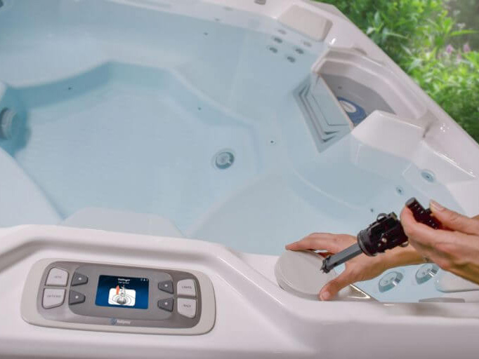Close-up of FreshWater Salt System cartridge installation on a hot tub, with instructions from the control panel.