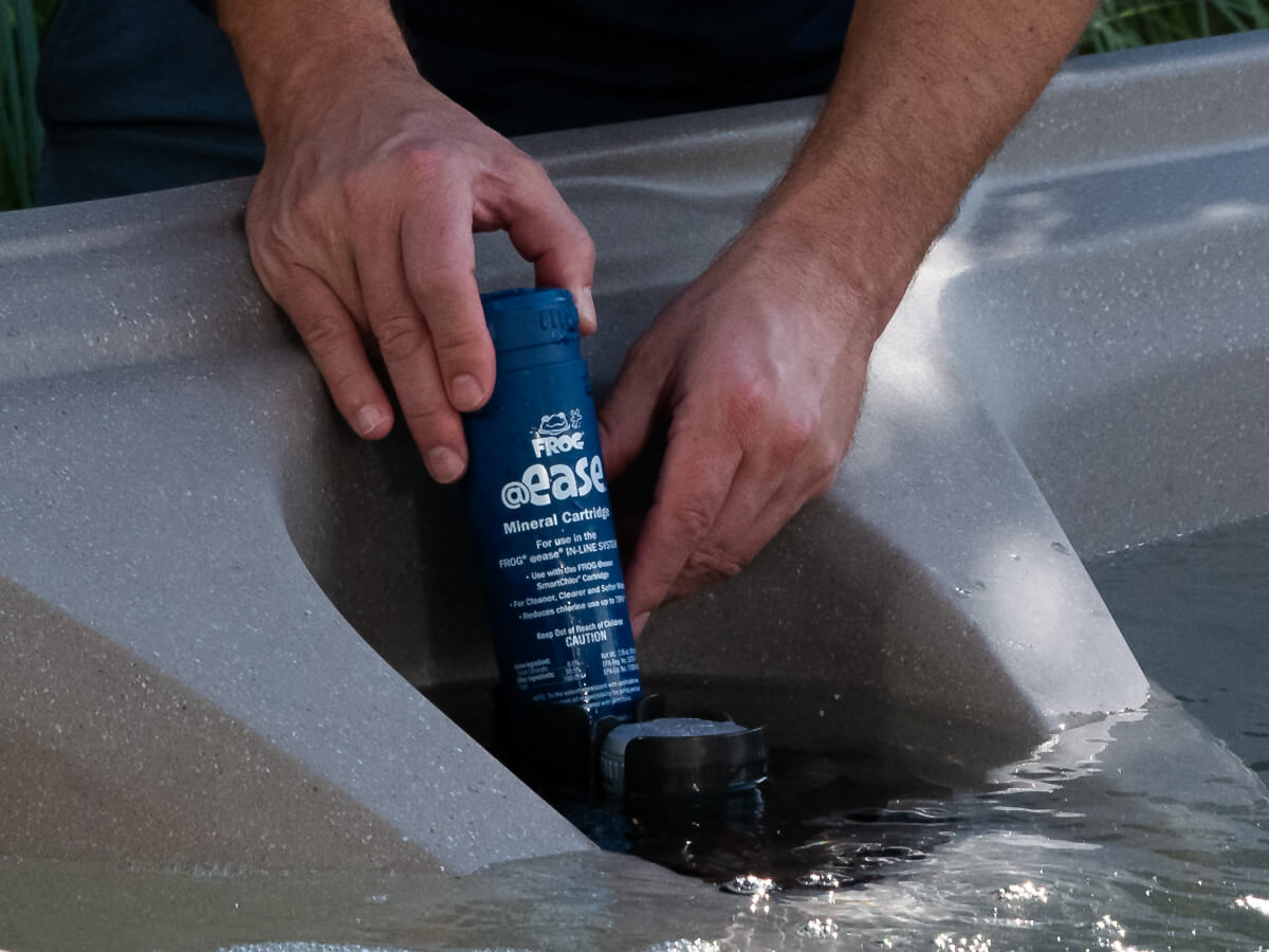 Man installing FROG @ease filter cartridge in Freeflow hot tub